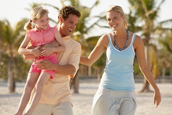 family of 3 smiling at camera